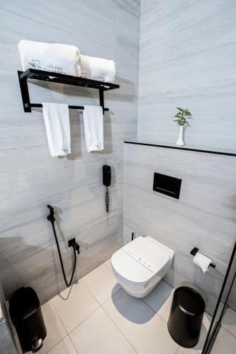 a bathroom with a white toilet and towels at Vivian Park El Raeid Hotel in Riyadh