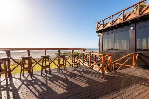 a deck with tables and chairs on the beach at Burning Shore Hotel in Langstrand