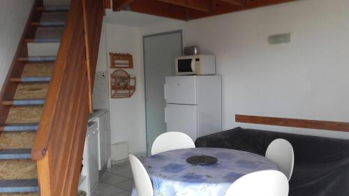 une table et des chaises dans une pièce avec un escalier dans l'établissement Palavas,T2 mezz terrasse parking, à Palavas-les-Flots