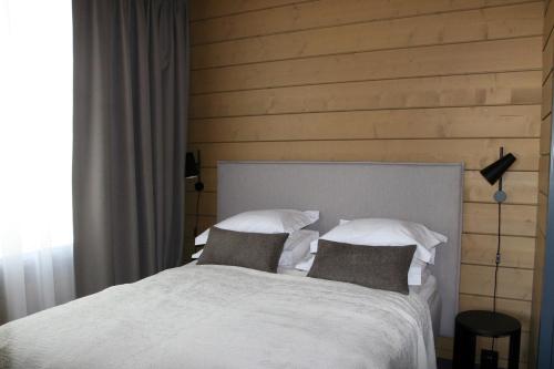 a bedroom with a white bed with two pillows at Levin Lyhty Beatrice by Hilla Villas in Kittilä