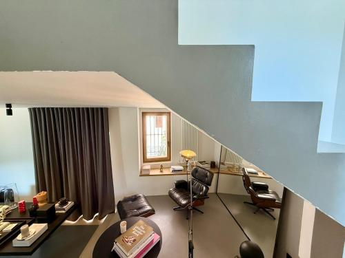 a living room with a couch and chairs and a staircase at Dimora Concept - Monti e Mare Exclusive Loft in Montalto Ligure