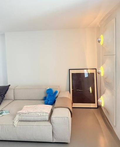 a living room with a couch with a teddy bear on it at Dimora Concept - Monti e Mare Exclusive Loft in Montalto Ligure