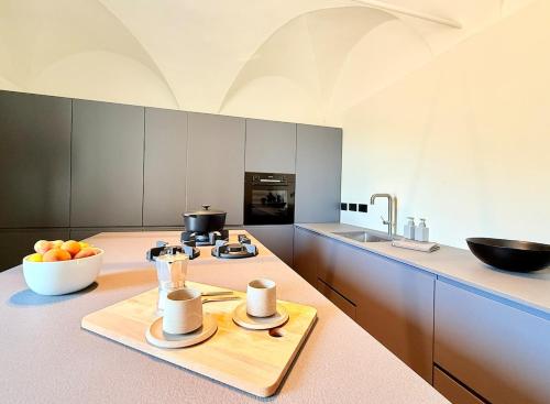 a kitchen with a counter with a chopping board and a bowl of fruit at Dimora Concept - Monti e Mare Exclusive Loft in Montalto Ligure