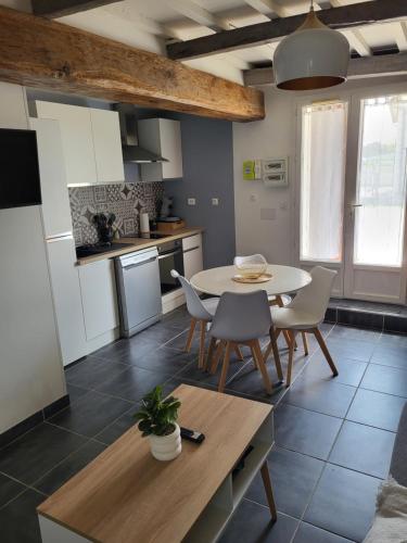 une cuisine et une salle à manger avec une table et des chaises dans l'établissement Jolie maison cosy en sologne, à Romorantin-Lanthenay