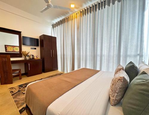 a bedroom with a large bed in front of a window at 360 Viewpoint by Queens Mount in Kandy
