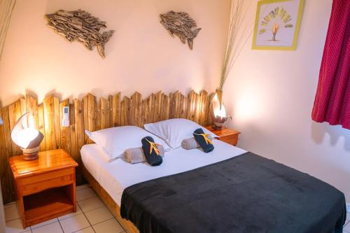a bedroom with a bed with a wooden headboard at Vacances pieds dans l'eau in Les Trois-Îlets