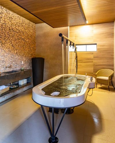 a bathroom with a bath tub with a shower at Rio Quente Resorts - Hotel Luupi in Rio Quente