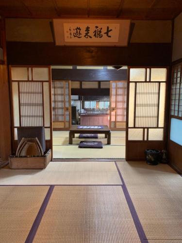 an entrance to a building with a room with a table at Old Japanese House in Tondabayashi