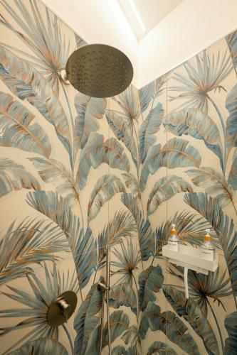 a bathroom with a mural of leaves on the wall at Oikos - Charm & Relax Procida in Procida