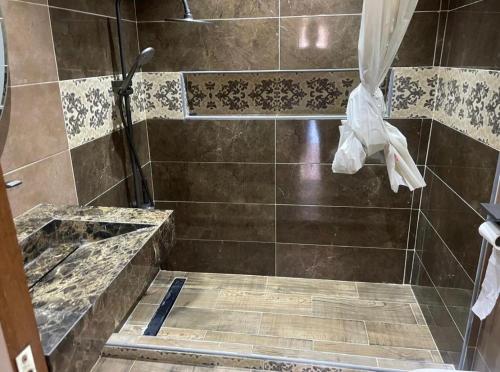 a bathroom with a shower with a tile floor at Ola Blanca in Dar Hamida