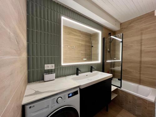 une salle de bain avec un lavabo et une machine à laver dans l'établissement Le Bellevue T3 - Orcières Merlette, à Orcières