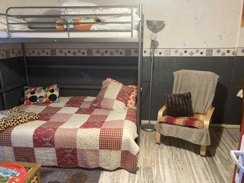 une chambre avec un lit superposé et une chaise dans l'établissement Studio MARMOTTES au RDC a HYPER centre du Mont DORE, à Mont-Dore