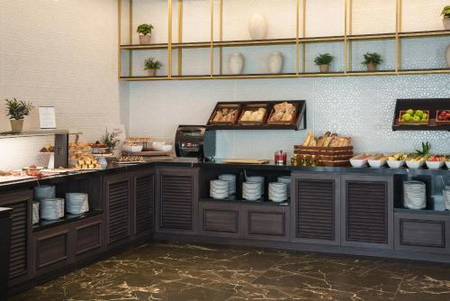 a kitchen with a counter with plates and food at Eurostars San Antón in Granada