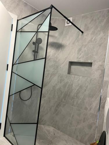a shower with a glass separator in a bathroom at Pristina Luxury Apartments 24 in Pristina