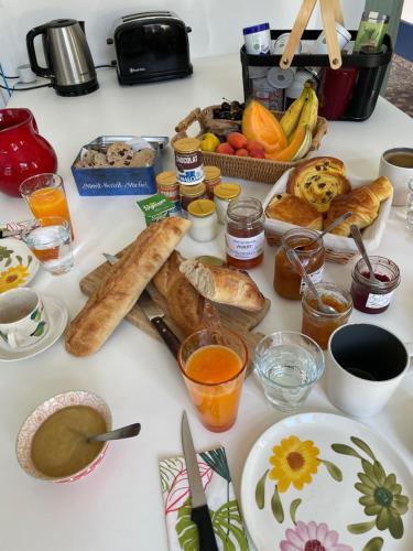 einen Tisch mit einem Haufen verschiedener Frühstückslebensmittel in der Unterkunft Le Petit Monde de Molly in Toucy