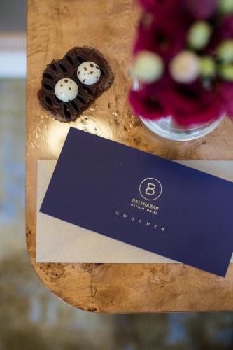 a blue card and some cookies on a table at Balthazar Design Hotel in Kraków
