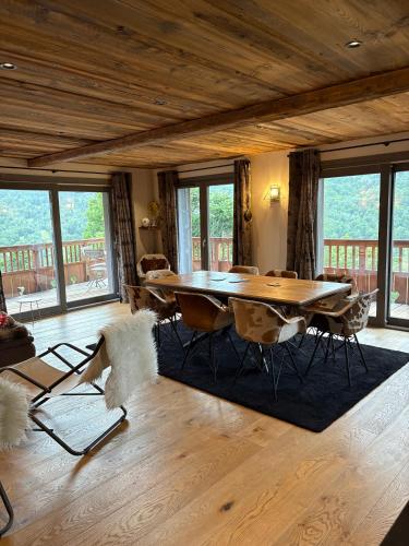 un salon avec une table et des chaises en bois dans l'établissement Méribel Village Luxury Apartment, à Les Allues