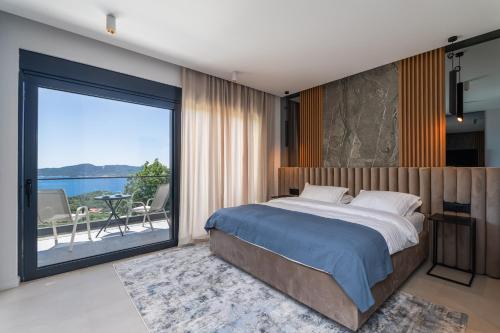 a bedroom with a large bed and a large window at Villa Blue Sunset in Brsečine