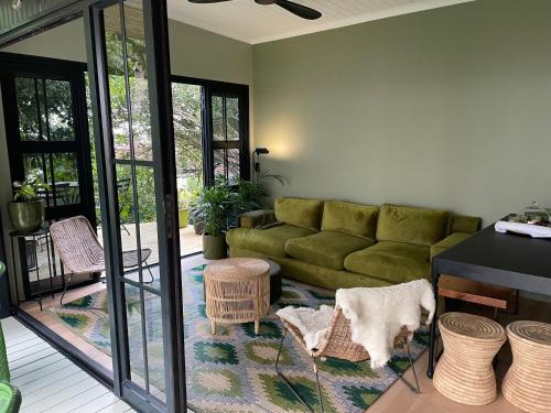 a living room with a green couch and some chairs at InAweStays Holiday Homes in Cape Town