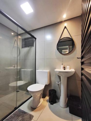 a bathroom with a toilet and a sink at Mini House 01 in Naviraí