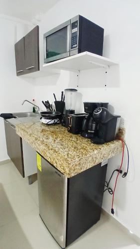 a kitchen with a counter top with a microwave at Villa Leo in Cancún