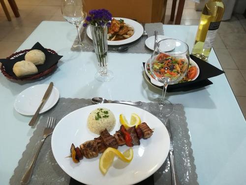 a table with plates of food and glasses of wine at Hotel Meia Lua in Ovar
