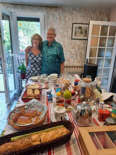 a man and woman standing at a table with food at Les Ecureuils in Revin