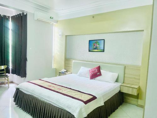 a bedroom with a large bed with a red pillow at Hotel Hoà Bình Riverside Văn Phú in Hà Ðông