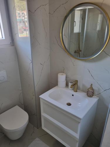 a bathroom with a white sink and a mirror at Villa Mila in Bol