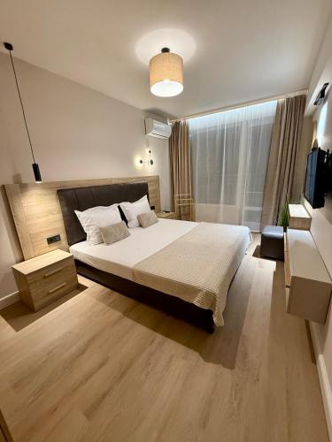a bedroom with a large bed and a large window at Апартамент Vista Al Mar in Pomorie