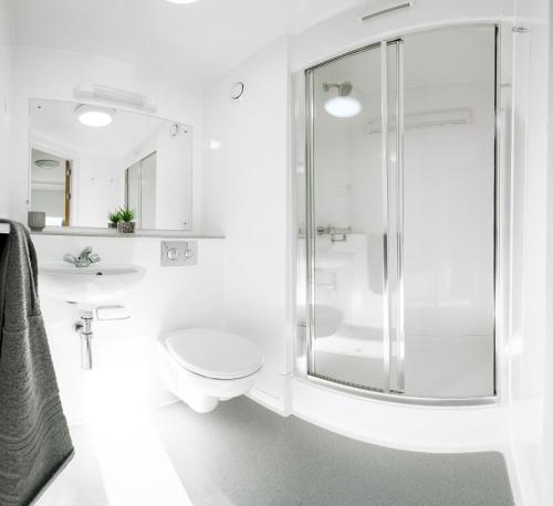 Un baño con ducha, inodoro y lavabo. en Petros Court, en Canterbury