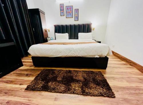 a bedroom with a bed and a rug on a wooden floor at The Boho Woods Resort in Nainital