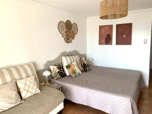 a bedroom with a bed and a couch at Le Cocon Créole studio vue mer Village Vacances in Sainte-Anne