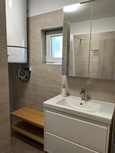 a bathroom with a white sink and a mirror at Bodza Vendégház in Badacsonyörs