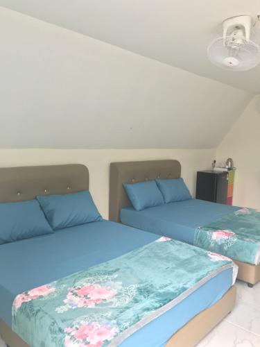 Family Cottage Beseri في كانجار: سريرين يجلسون بجانب بعض في غرفة النوم