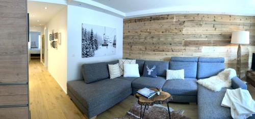 a living room with a blue couch and a brick wall at Spacious 3 Room Apartment - Family-Friendly - Central Leukerbad - Great Views in Leukerbad