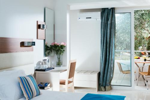 a bedroom with a bed and a desk and a table at Elounda Akti Olous (Adults Only) in Elounda