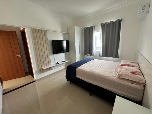 una camera da letto con un letto e una TV a schermo piatto di VISTA MAR 3 apt6 a Porto Seguro