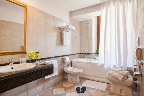 łazienka z wanną, toaletą i umywalką w obiekcie Atlante Garden Hotel w Rzymie