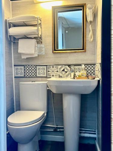 a bathroom with a toilet and a sink and a mirror at Hôtel Paul Riquet in Béziers