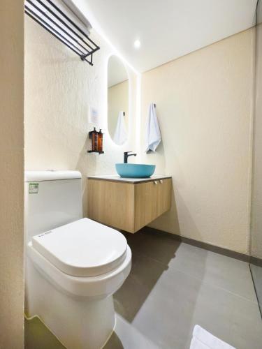 a bathroom with a white toilet and a sink at Hotel Once22 in Sabaneta