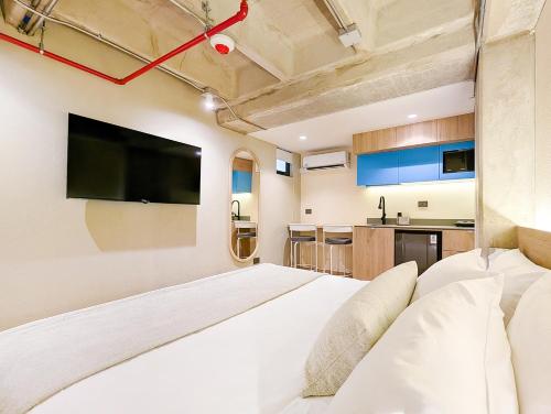 a bedroom with a large bed and a flat screen tv at Hotel Once22 in Sabaneta