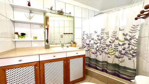 a bathroom with a sink and a shower curtain at Welooveyou Honey in Costa Calma