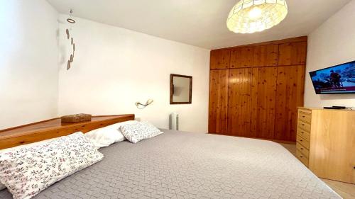 a bedroom with a large bed and a wooden cabinet at Welooveyou Honey in Costa Calma