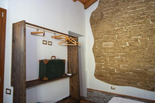 a room with a brick wall and a green bag at Sole Melis in Solèminis