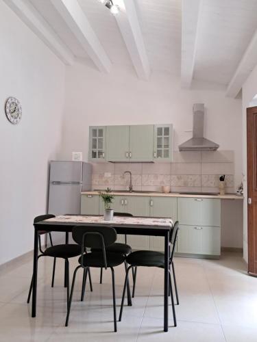 a kitchen with a table and chairs in a room at Purtusu's House in Pachino