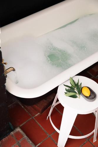 a bath tub with a plate of fruit on a side table at InAweStays Holiday Homes in Cape Town