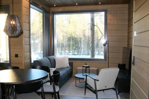 a room with a couch and a table and a window at Levin Lyhty Bettina by Hilla Villas in Kittilä