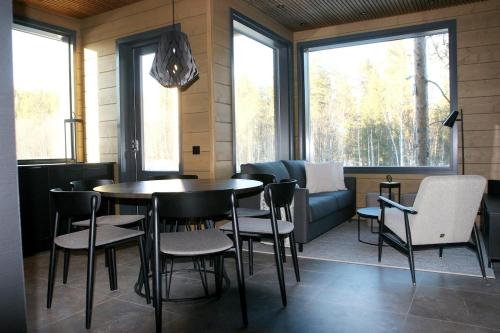 a dining room with a table and chairs and a couch at Levin Lyhty Bettina by Hilla Villas in Kittilä