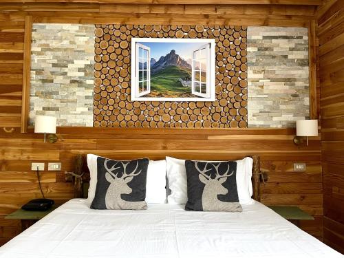 Una cama o camas en una habitación de Hotel Rododendro Val di Fassa